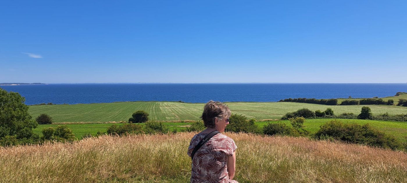 Yvonne Engelen in het gras met uitzicht over de zee